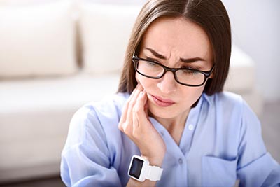 woman with tooth pain in need of an emergency dentist in Laredo, TX