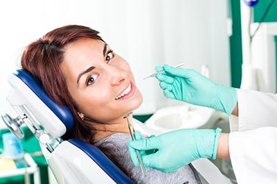 woman smiling while having her teeth cleaned in Laredo, TX